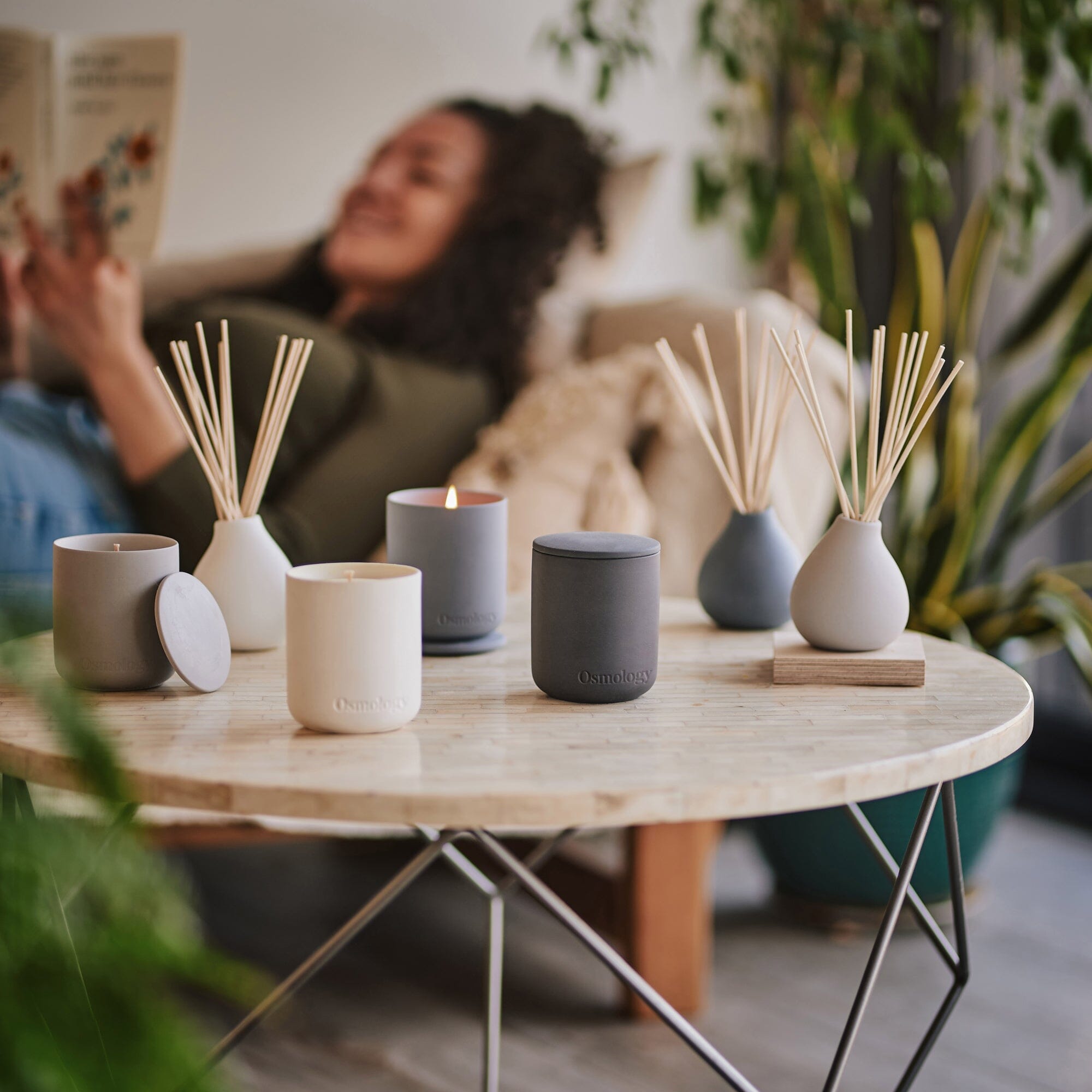 a collection of ceramic candles and diffusers displayed on coffee table by osmology