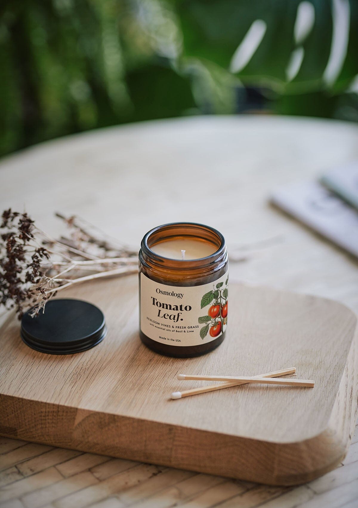 Tomato Leaf jar candle by Osmology on wooden tray with match sticks 