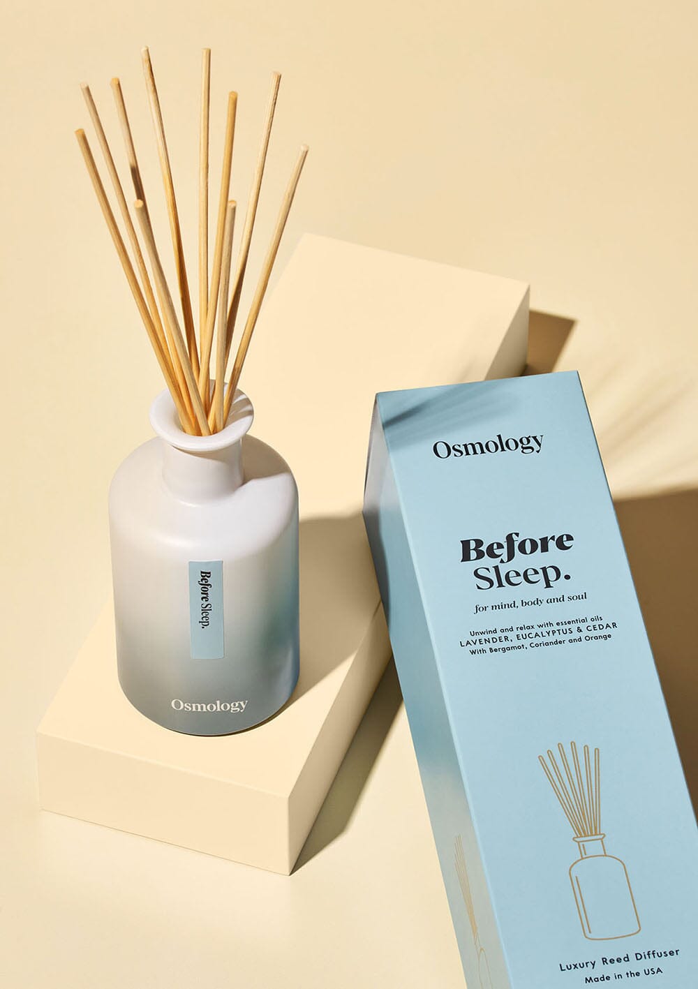 Osmology before sleep diffuser and blue product packaging on a yellow-cream background