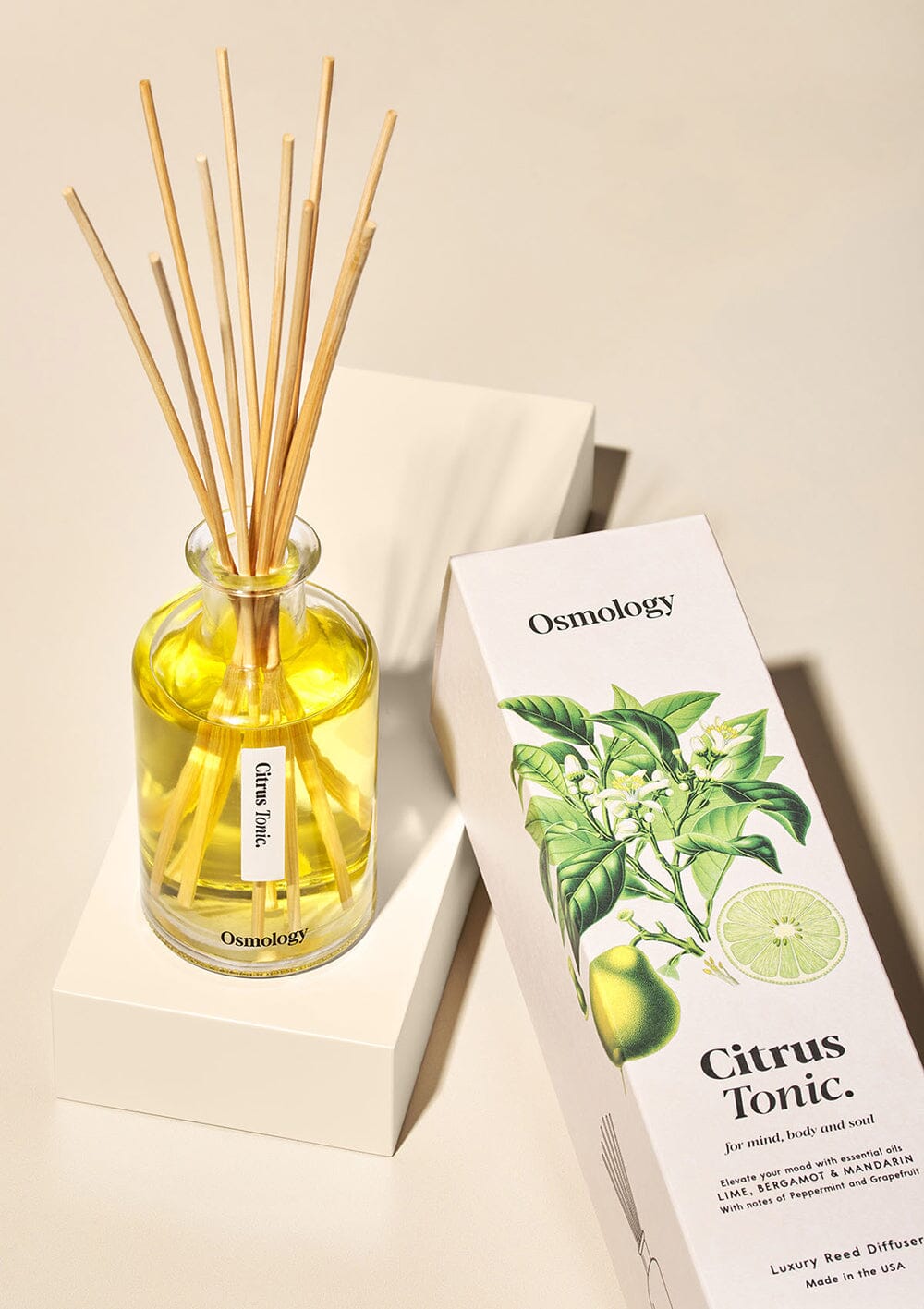 Osmology Citrus Tonic reed diffuser and decorative product packaging on a cream background