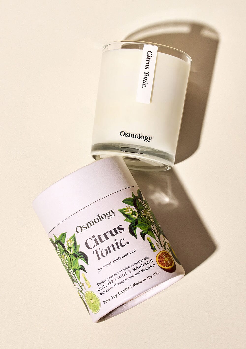 Citrus Tonic candle displayed next to illustrated product packaging on white background