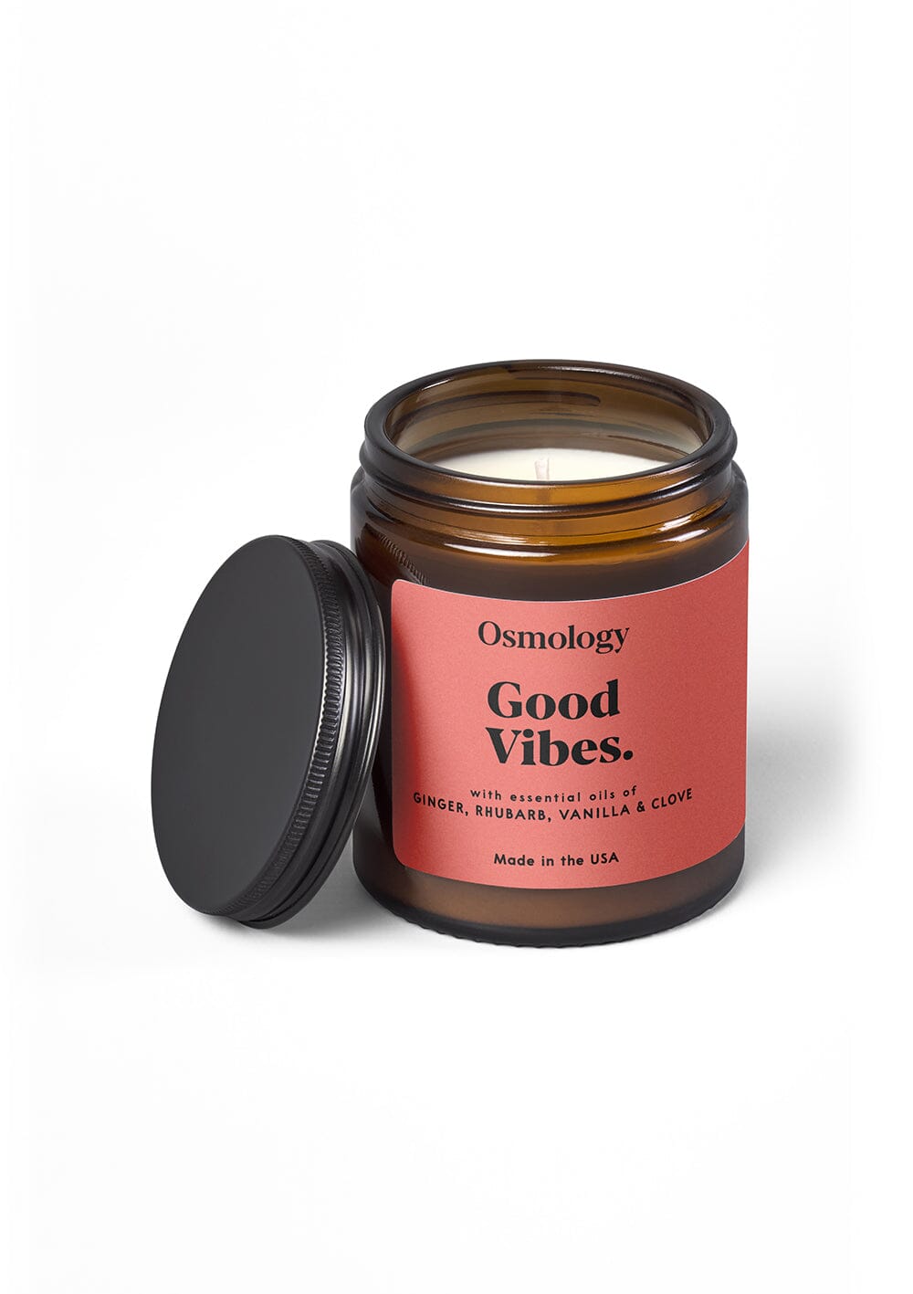 Osmology Good Vibes jar candle, with lid leant against it, on white background