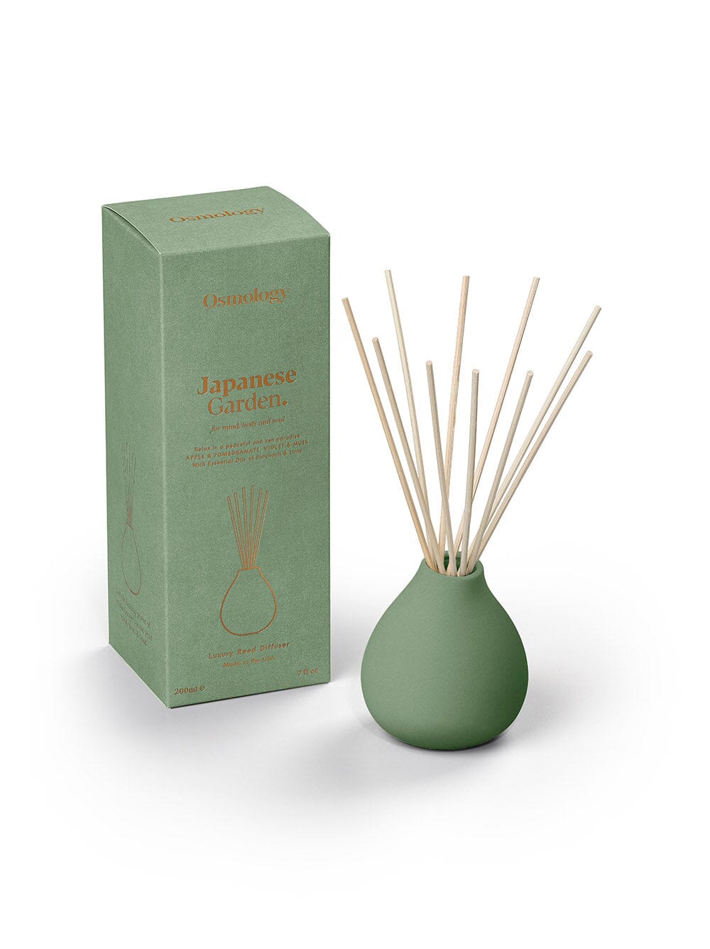 Osmology green ceramic reed diffuser next to product packaging on a white background