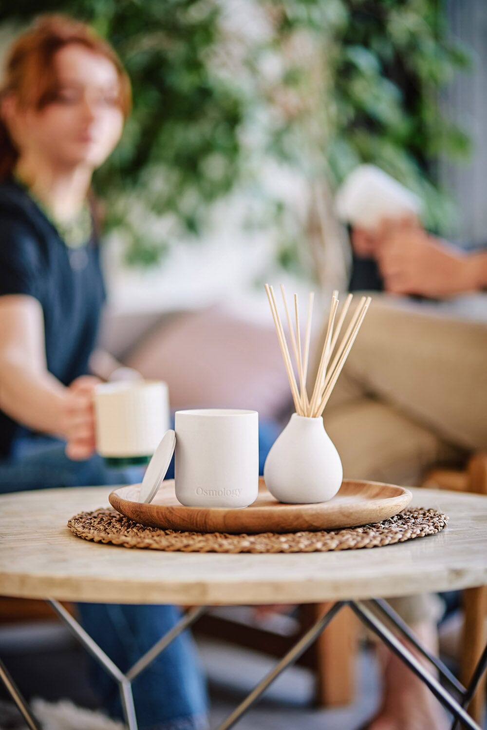 Osmology Nordic Cedar Diffuser with Nordic Cedar candle on wooden tray, on coffee table 