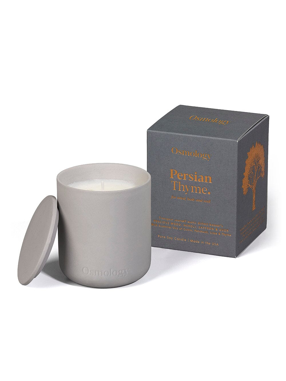 Osmology persian thyme scented candle displayed on it's side next to matching lid and product packaging