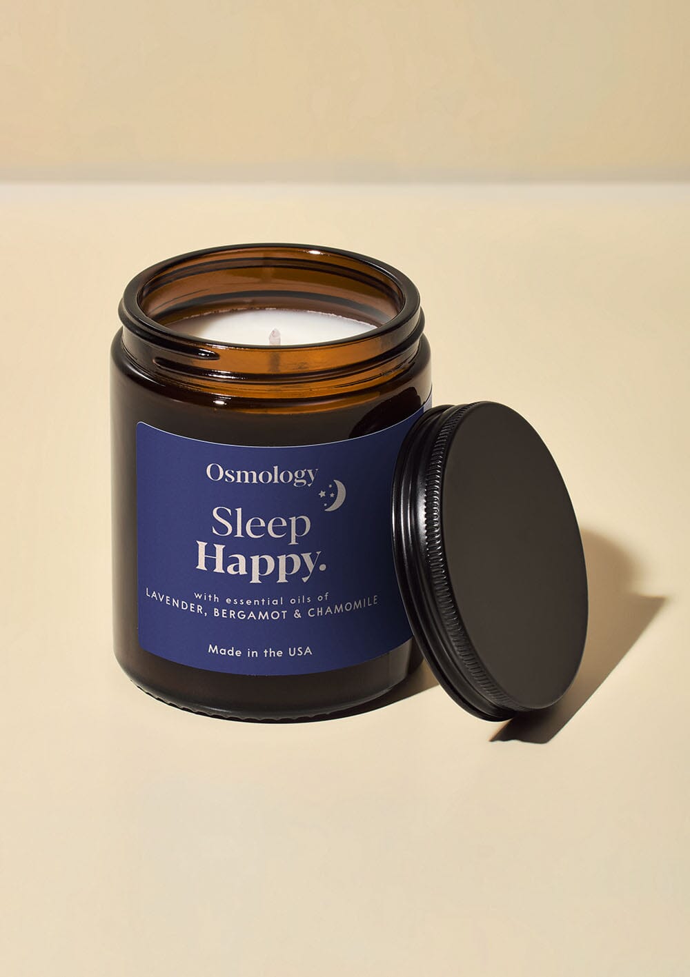 Osmology Sleep Happy jar candle with open lid on cream background